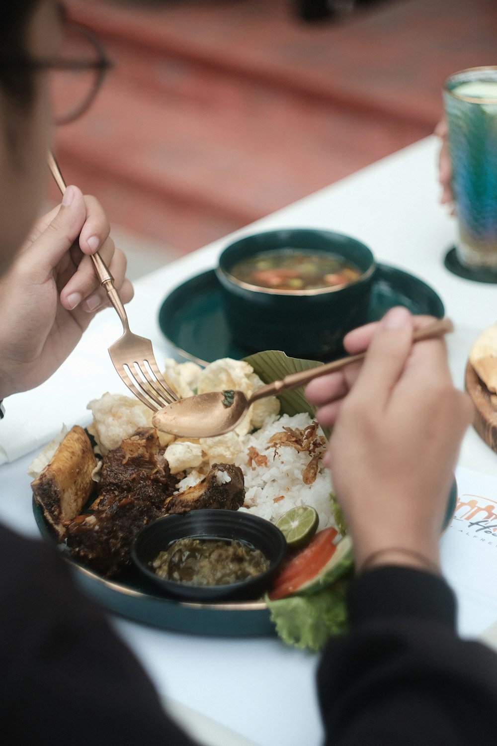 a person sitting at a table with a plate of food