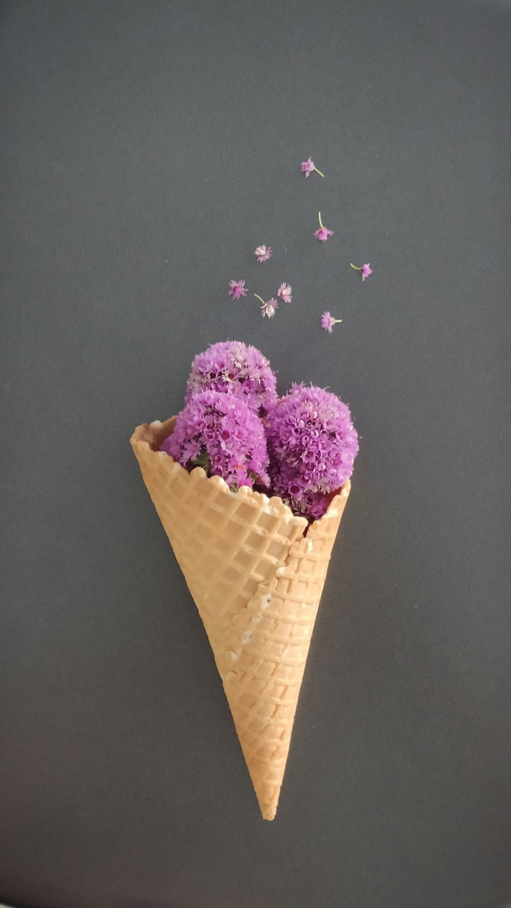 a cone filled with purple flowers on top of a table