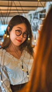 A candid, tasteful shot of a college girl in a cozy dorm room setting, smiling softly while sitting comfortably.