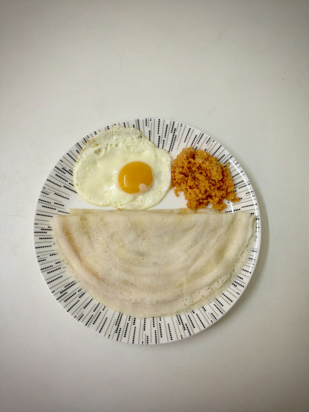 a plate of food that includes an egg and a pita bread