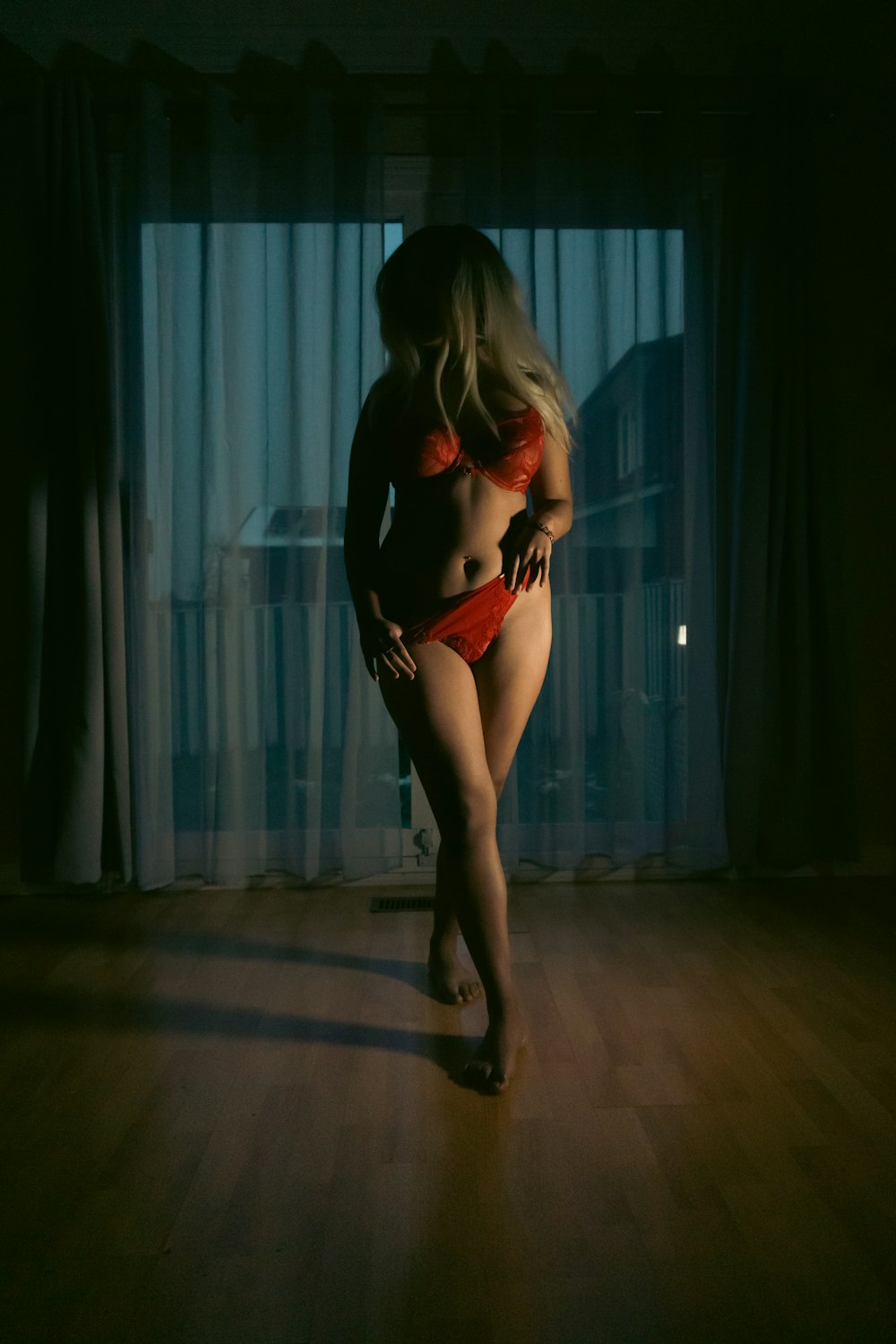a woman in a red bikini standing in a dark room