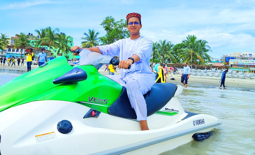 a man sitting on a jet ski on the beach