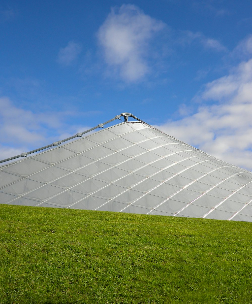 a green field with a large glass building in the background