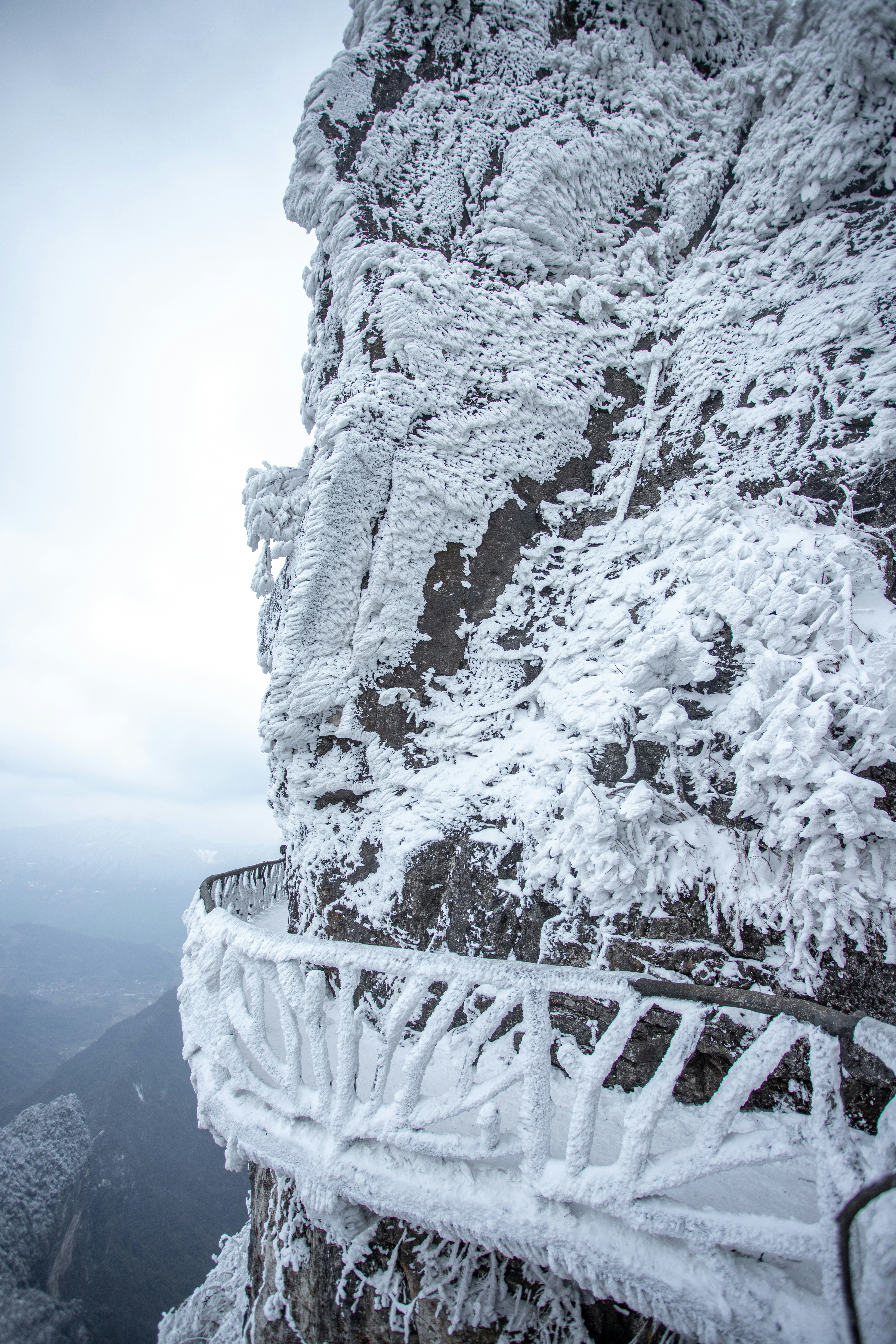 A snow covered mountain side with a metal railing photo – Free Blue ...