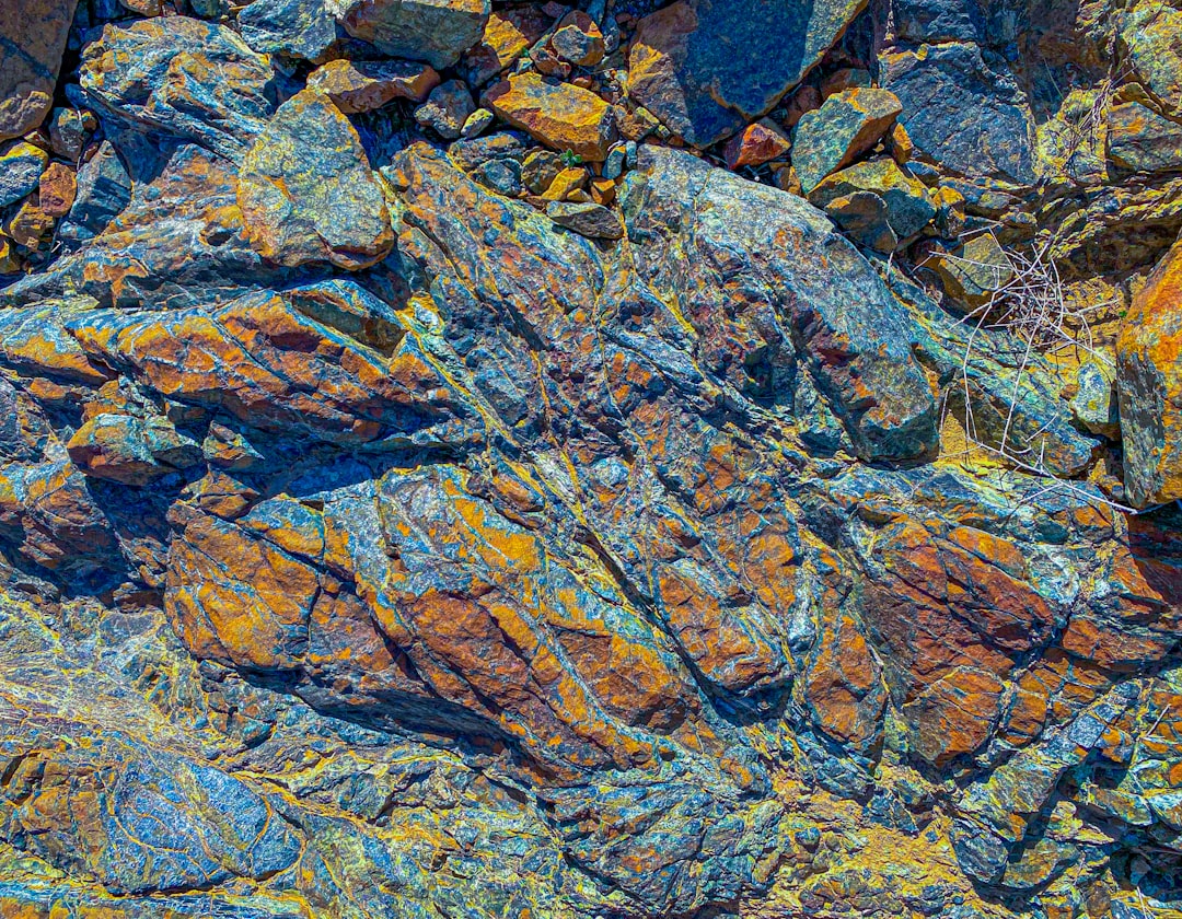 a close up of a rock with yellow and blue colors, Bright rocky texture stones