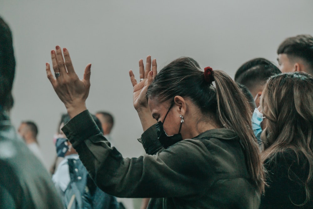 a group of people standing in a room with their hands in the air