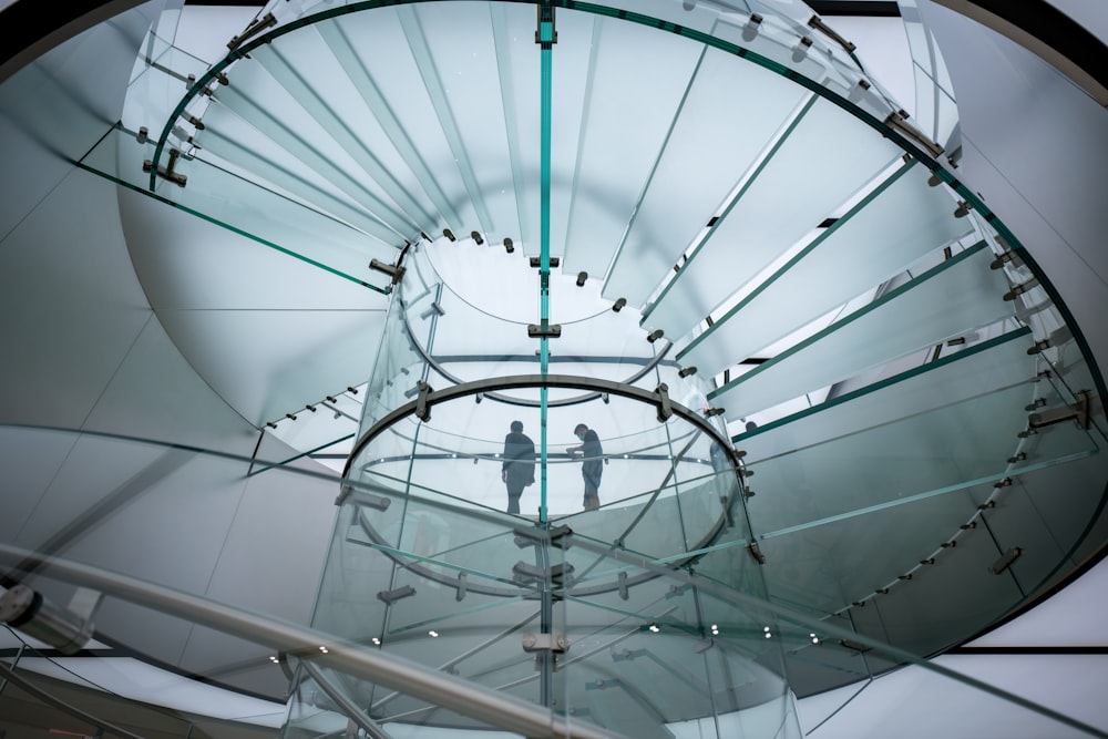 a man is standing on a glass staircase