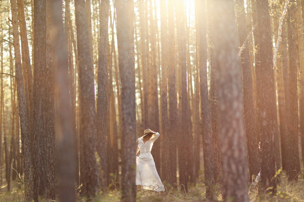 a woman standing in the middle of a forest