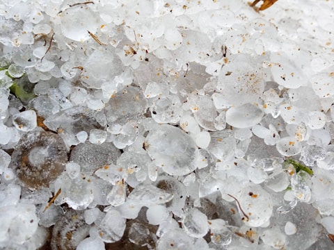 Close-up of a roof battered by hailstones with visible dents.