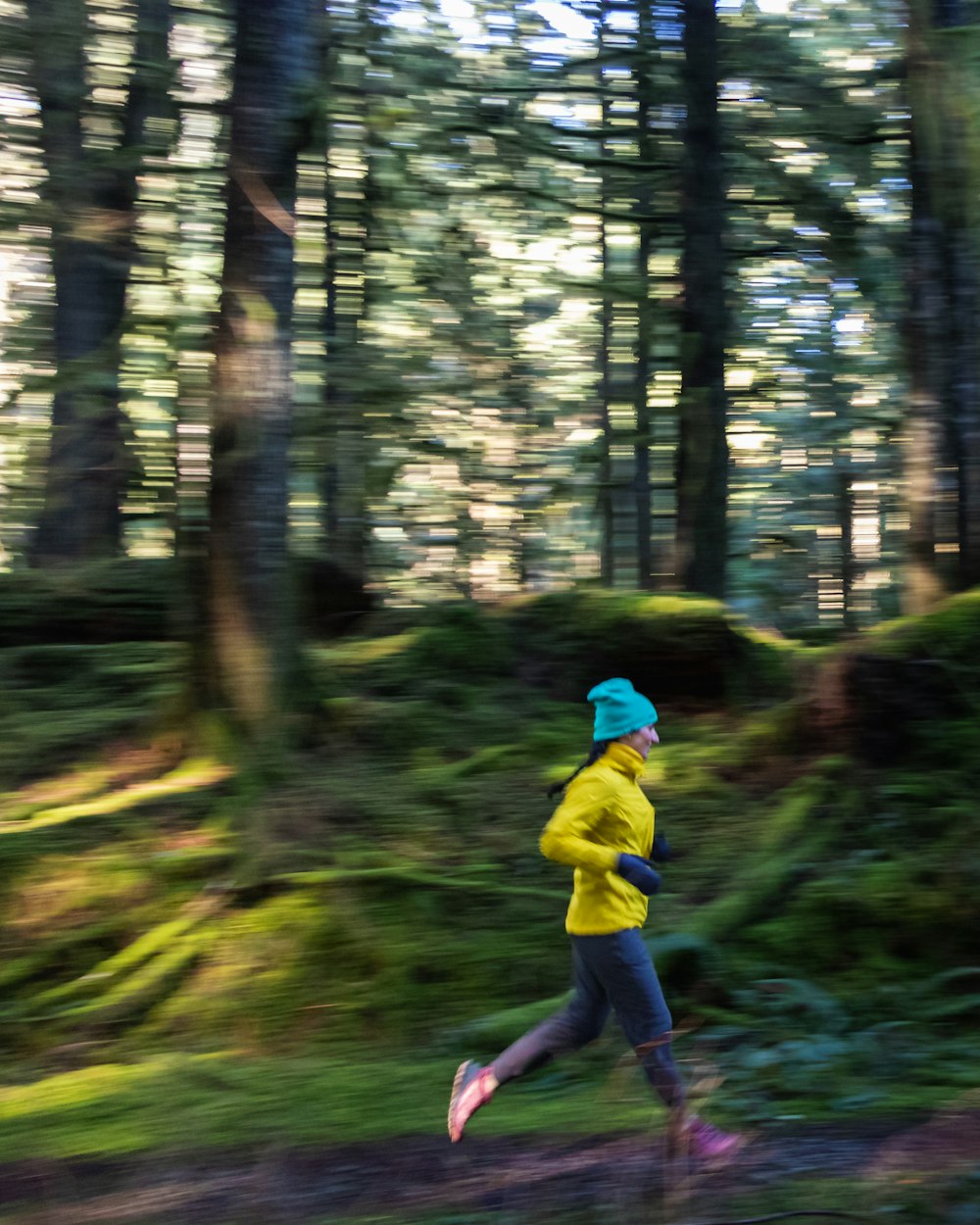 a person running in the woods with trees in the background