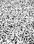 A black and white terrazzo pattern with irregular, randomly distributed black stone-like fragments set in a white matrix.