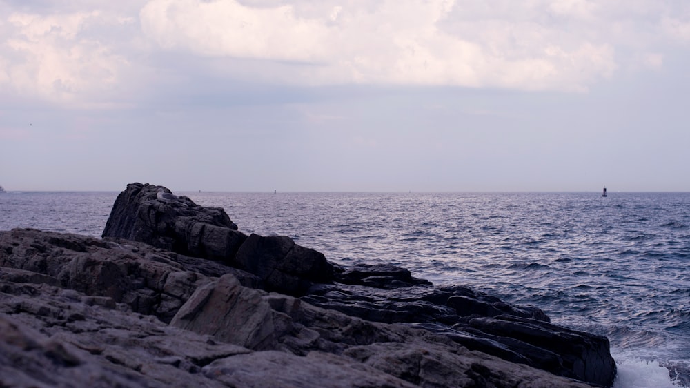 a lone boat is in the distance on the ocean