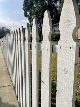 A professional installer fitting a sleek vinyl fence on a sunny Florida residential property.