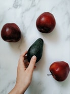 a person is peeling an avocado on a table