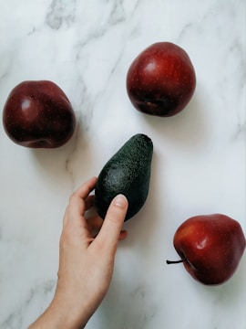 a person is peeling an avocado on a table