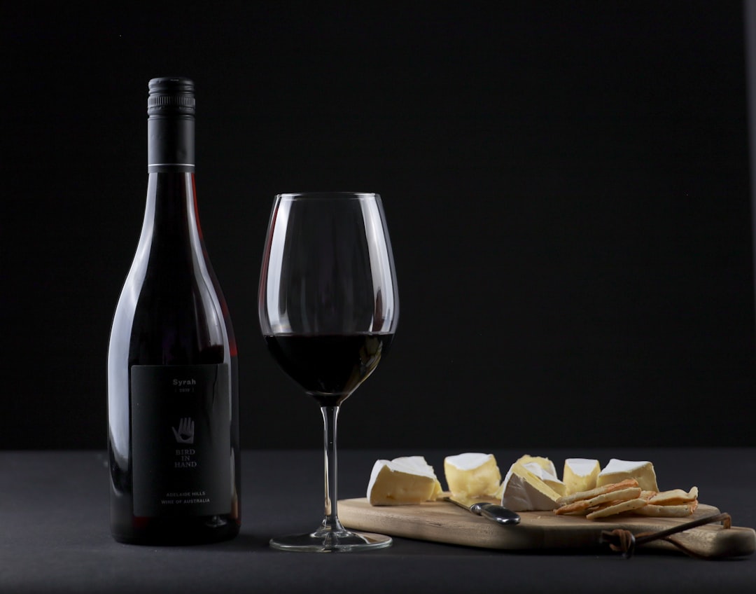 a bottle of wine and a glass of wine on a table,