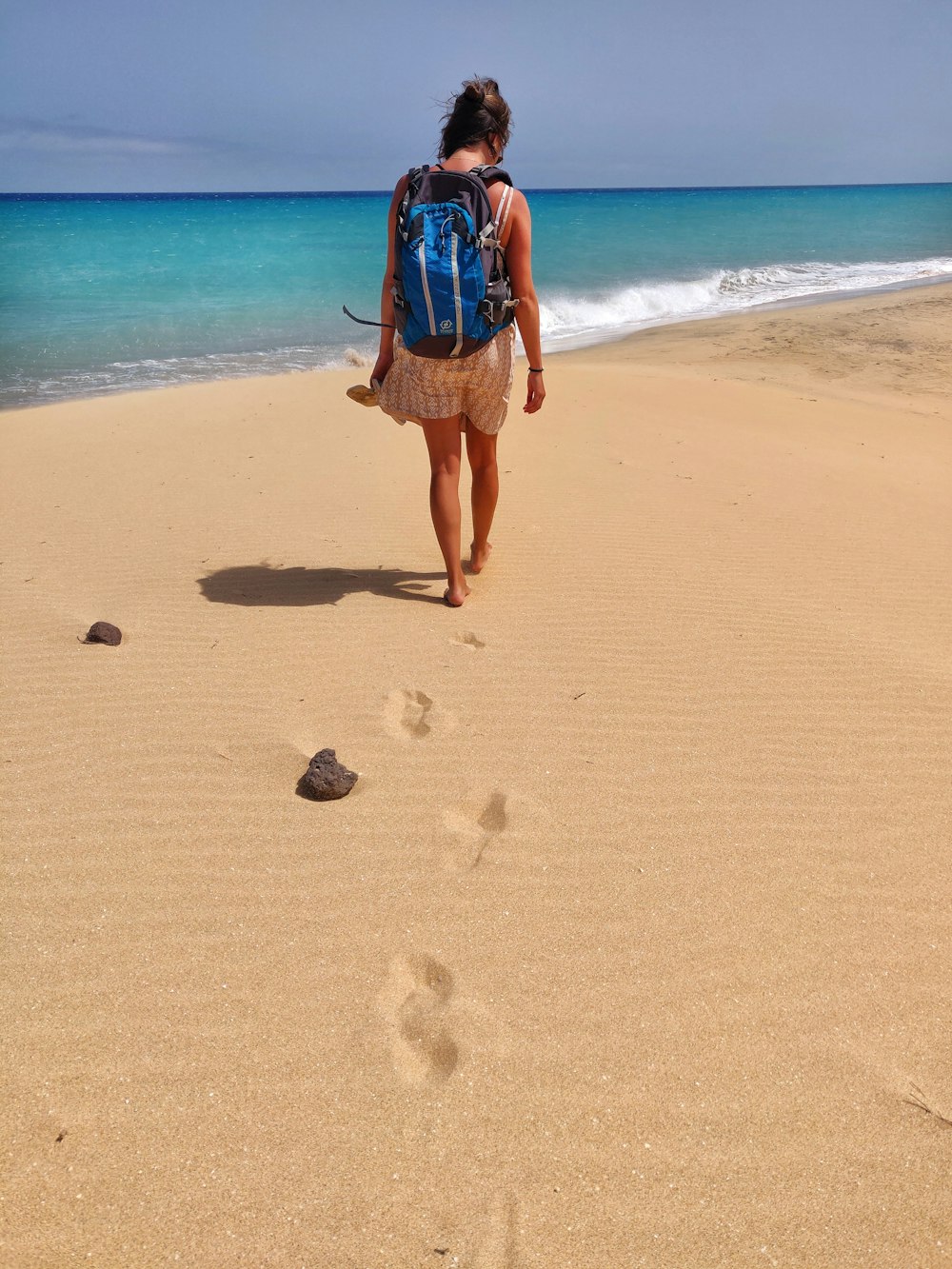 Foto Una mujer caminando por la playa con una mochila – Imagen Playa de  arena gratis en Unsplash