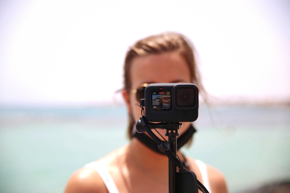 a woman holding a camera in front of her face