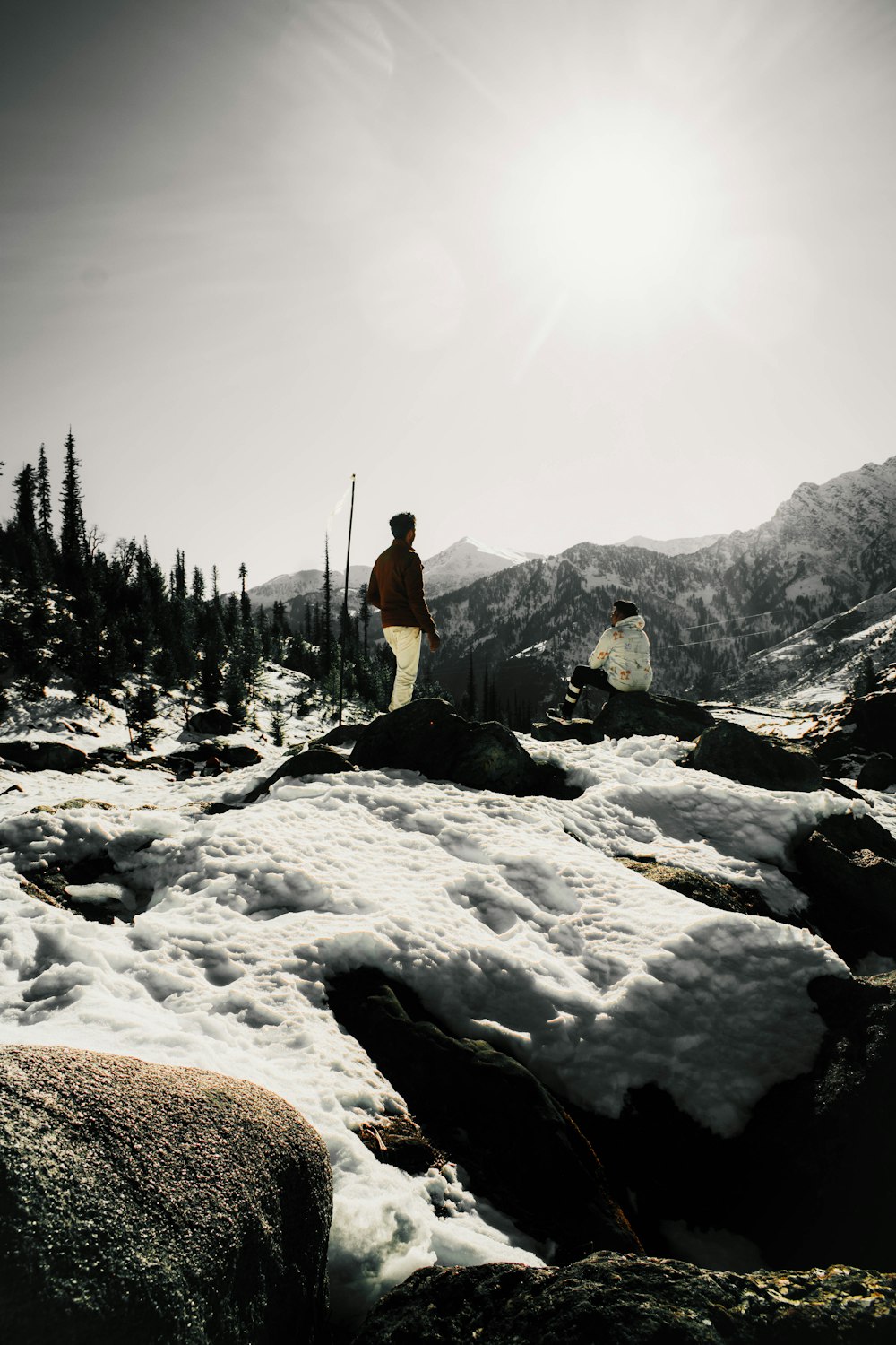 a couple of people standing on top of a snow covered slope