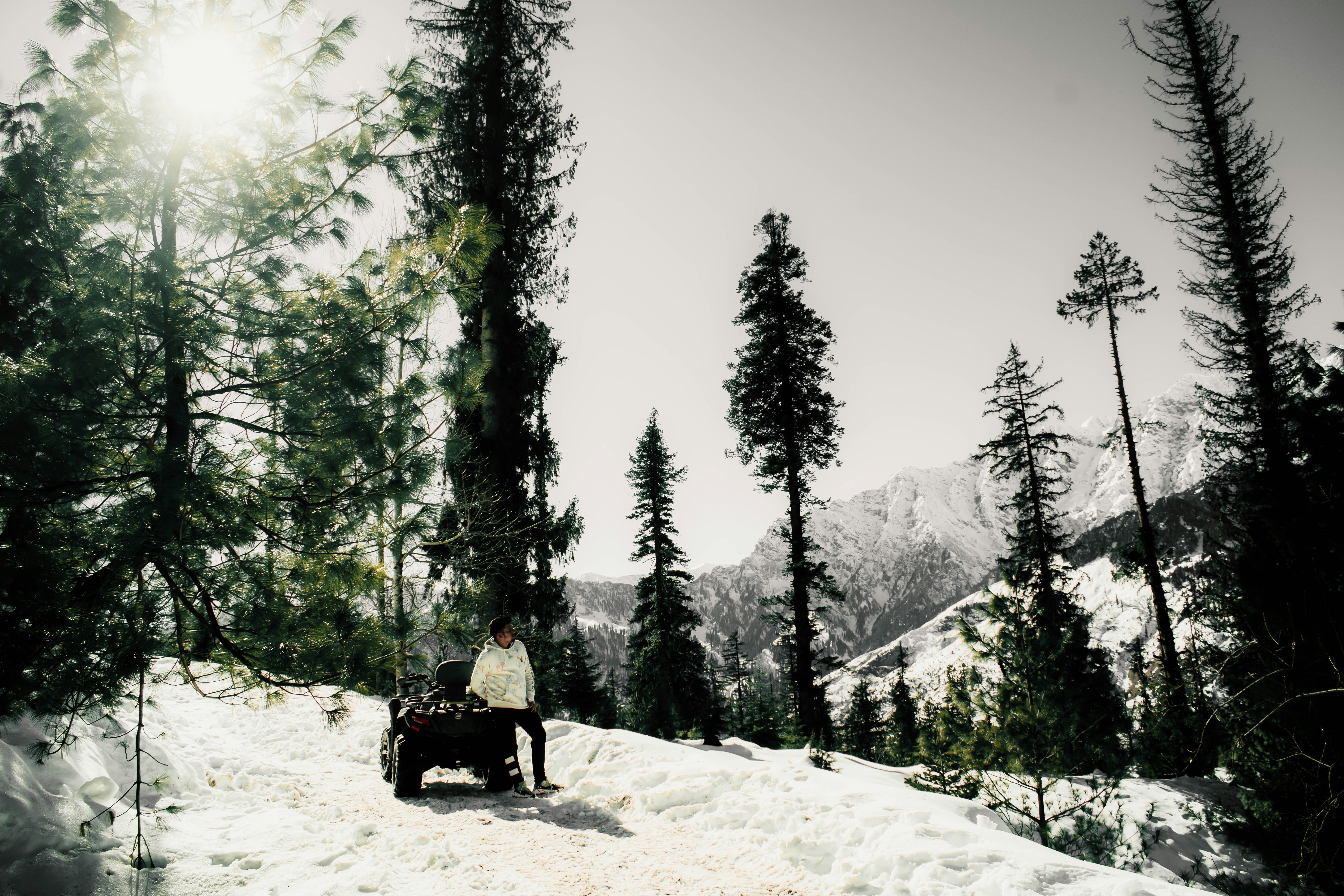 a man riding a snowmobile down a snow covered slope