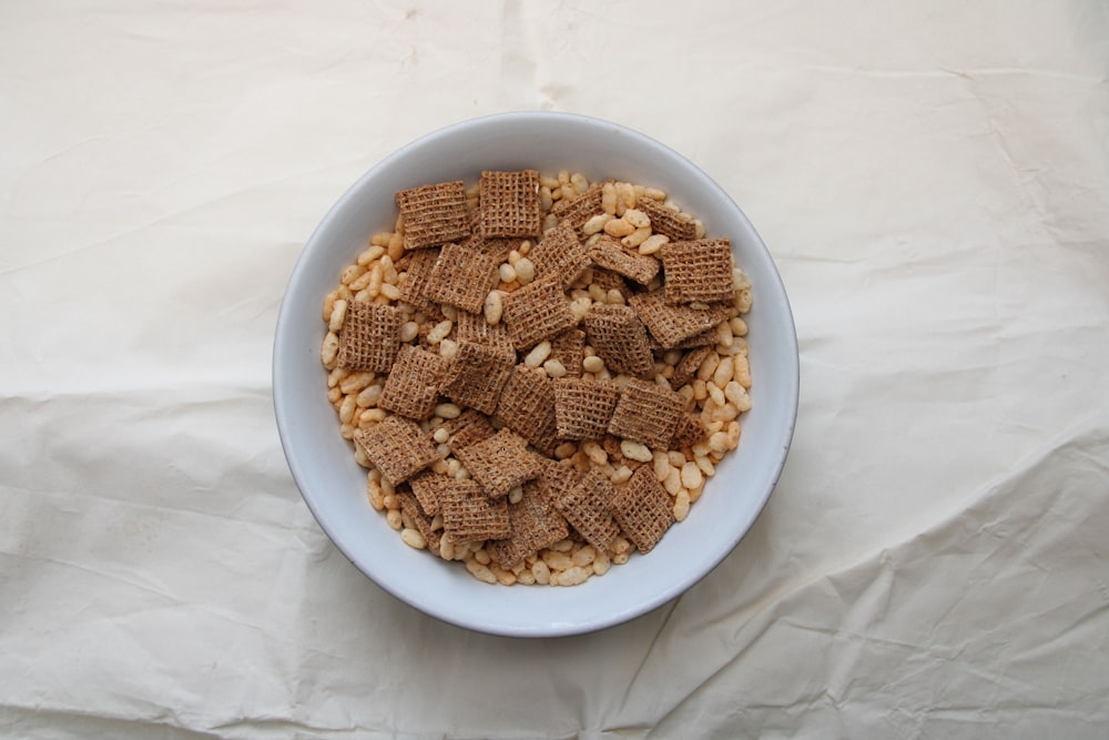 a white bowl filled with cereal on top of a white table