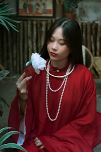 a woman in a red dress holding a flower