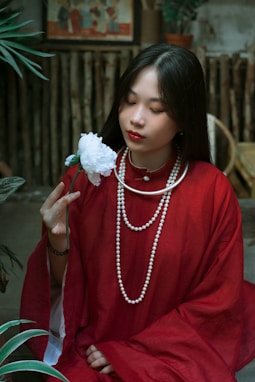 a woman in a red dress holding a flower
