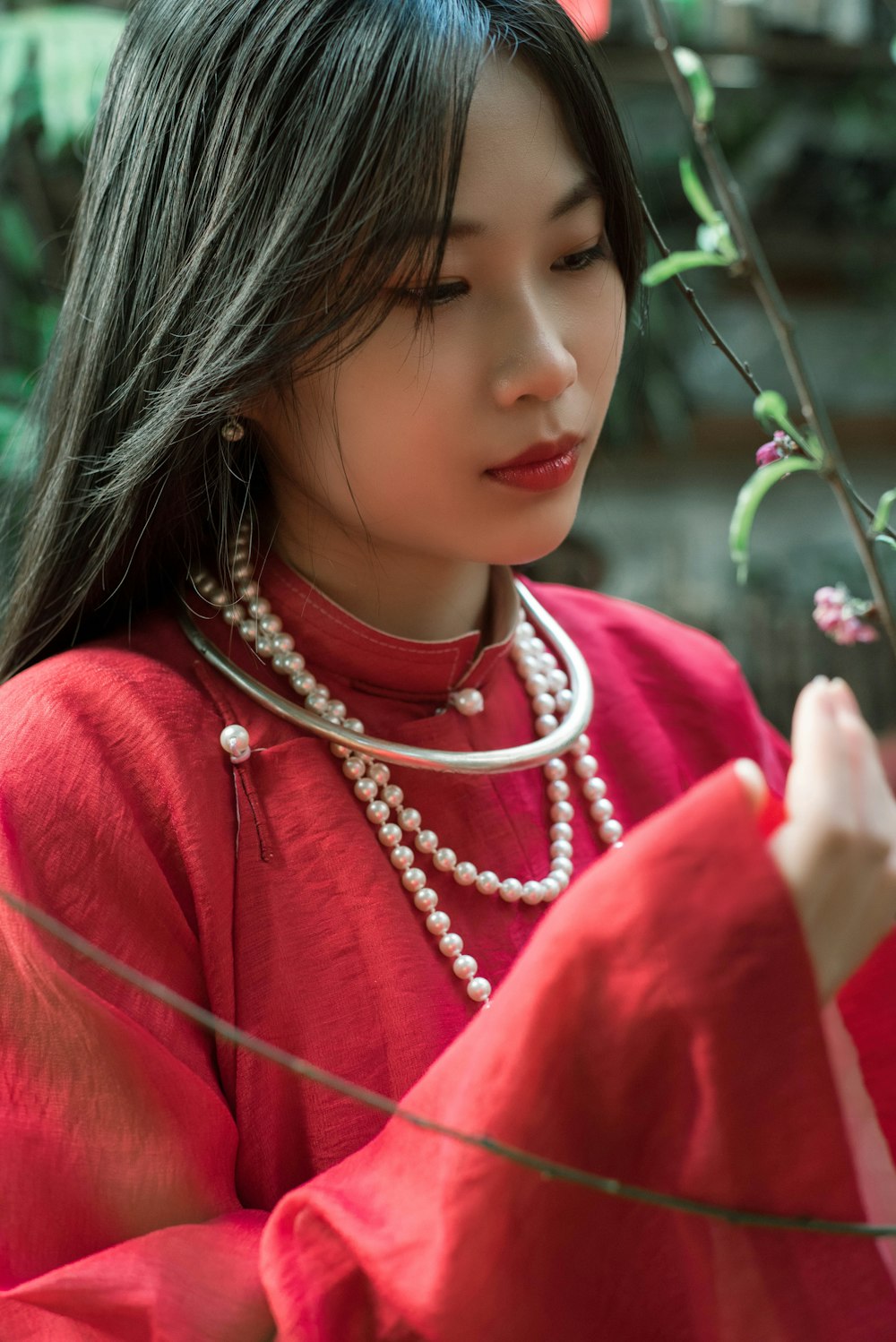 a woman in a red dress holding a flower