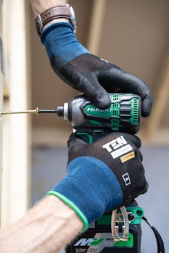 a person with a drill driver on top of a piece of decking