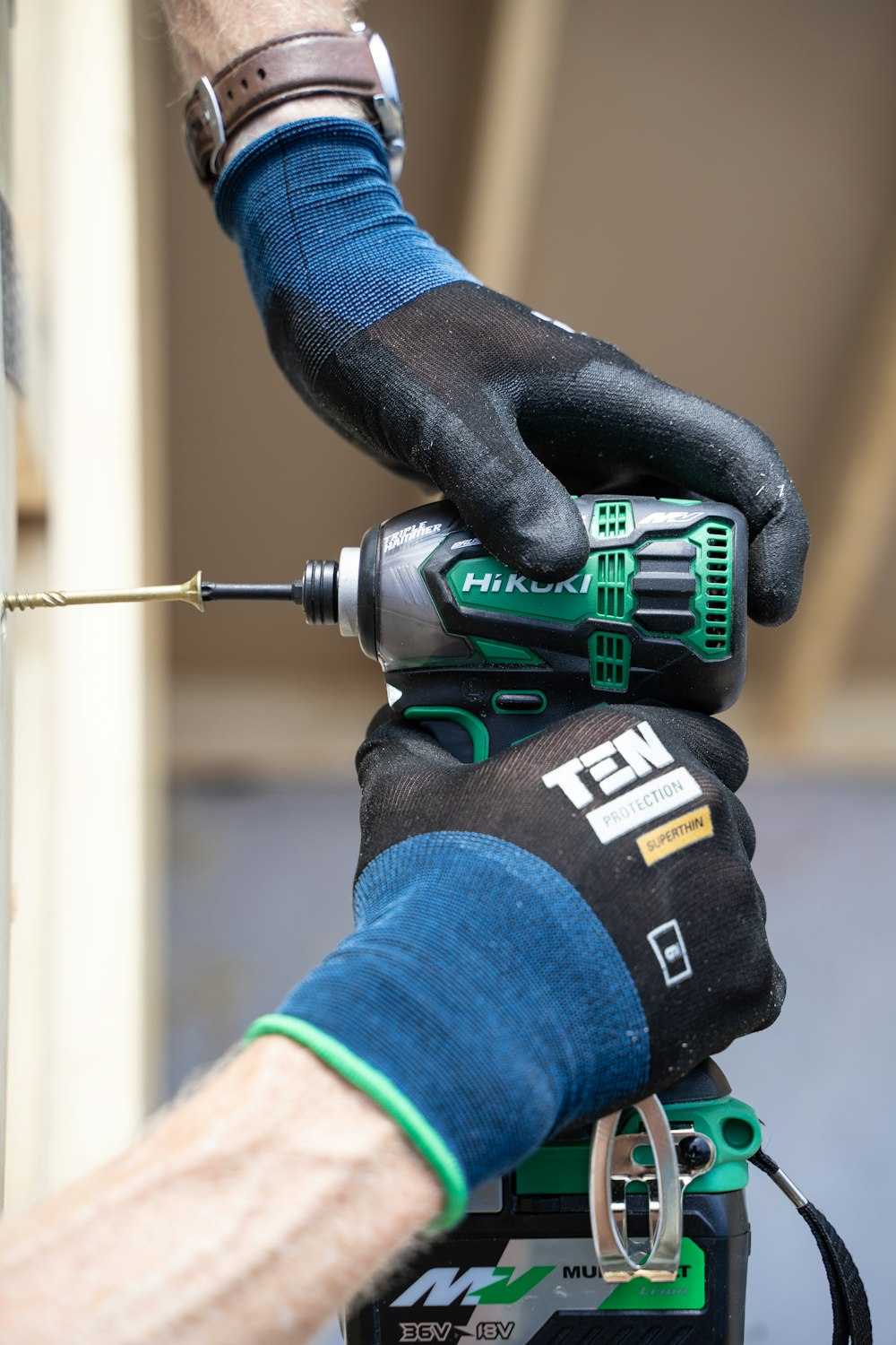 a person with a drilldriver on top of a piece of equipment