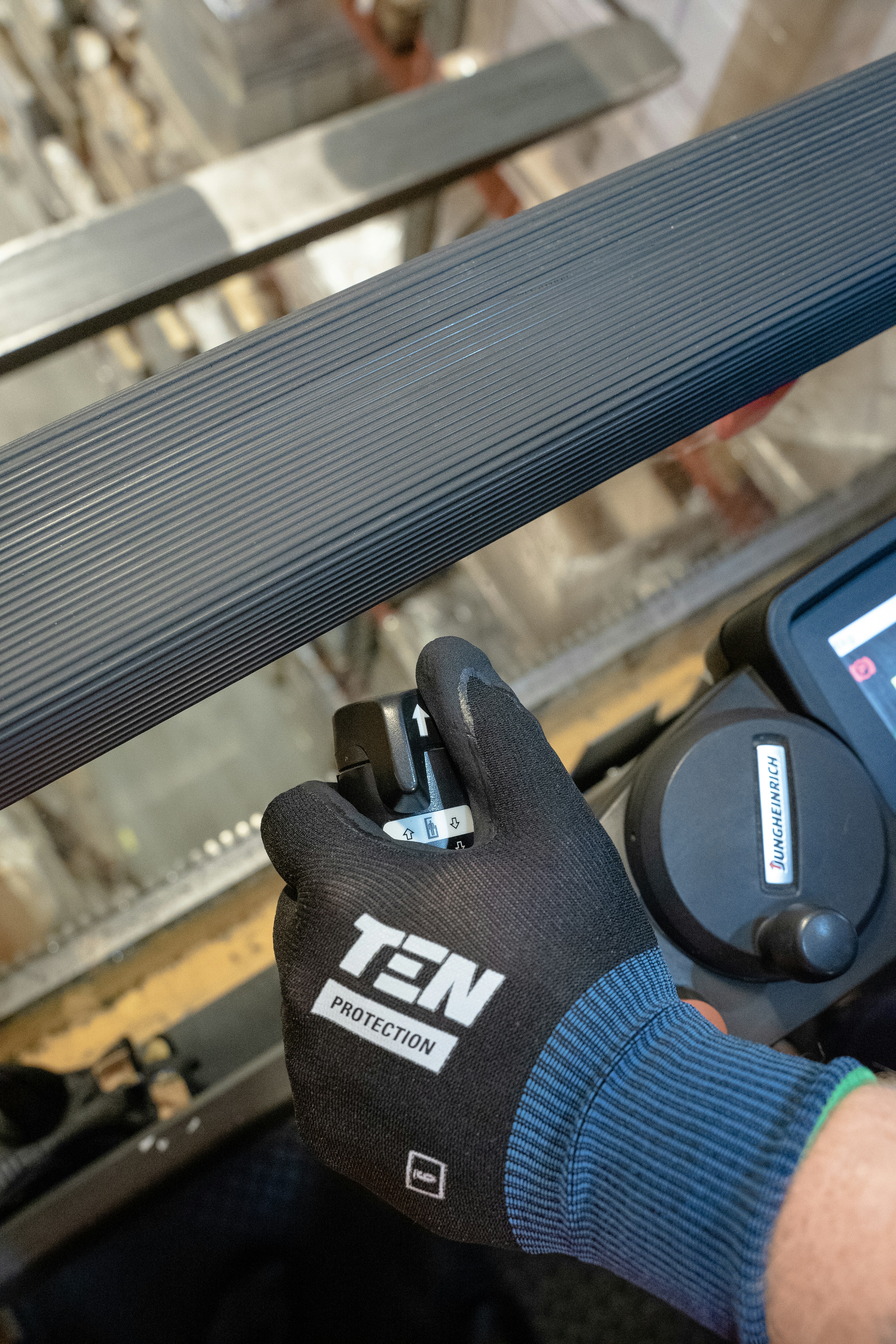 Eine Person mit einem Handschuh bei der Arbeit an einer Maschine