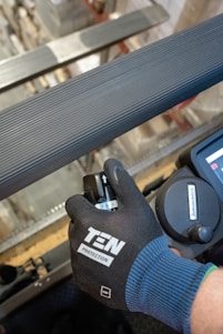 a person with a glove on working on a machine