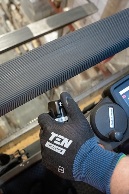 a person with a glove on working on a machine