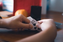 a person holding a piece of paper with playing cards on it