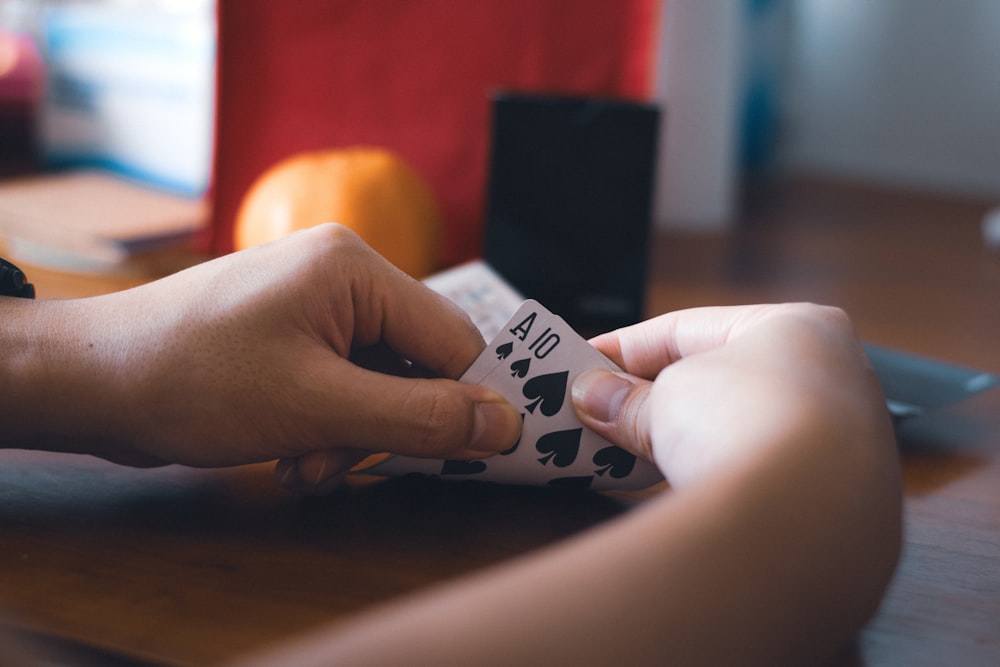 une personne tenant un morceau de papier avec des cartes à jouer dessus