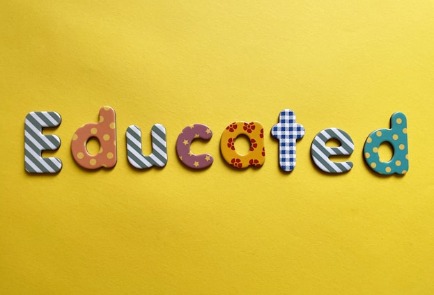 Various letters spelling out the word 'Educated' on a yellow background. Each letter is uniquely designed with different patterns and colors.