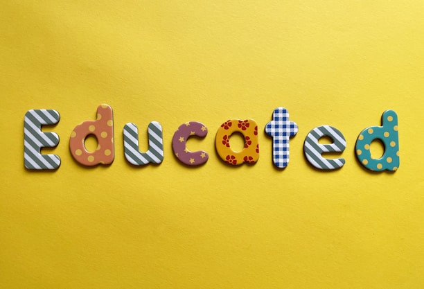Various letters spelling out the word 'Educated' on a yellow background. Each letter is uniquely designed with different patterns and colors.