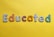 Various letters spelling out the word 'Educated' on a yellow background. Each letter is uniquely designed with different patterns and colors.