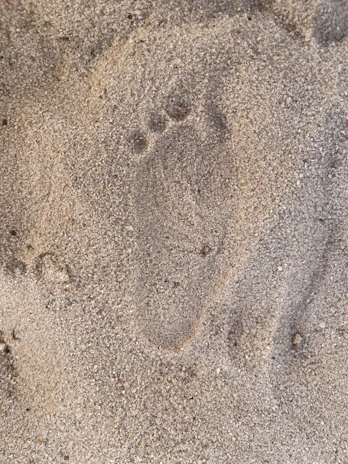 Footprints in the sand showing recent boots-on-the-ground inspection.