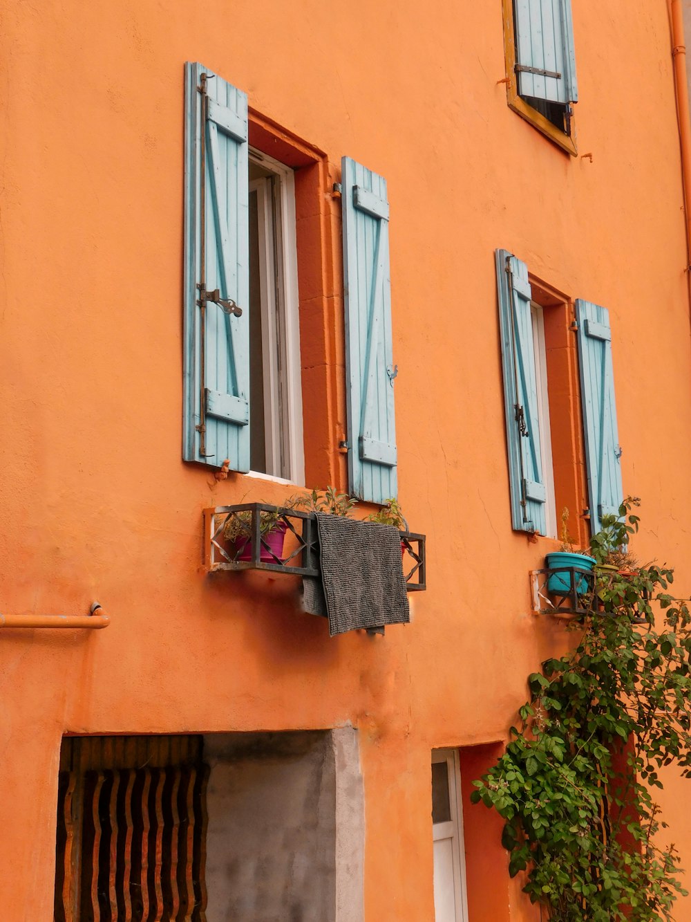 an orange building with blue shutters and a window