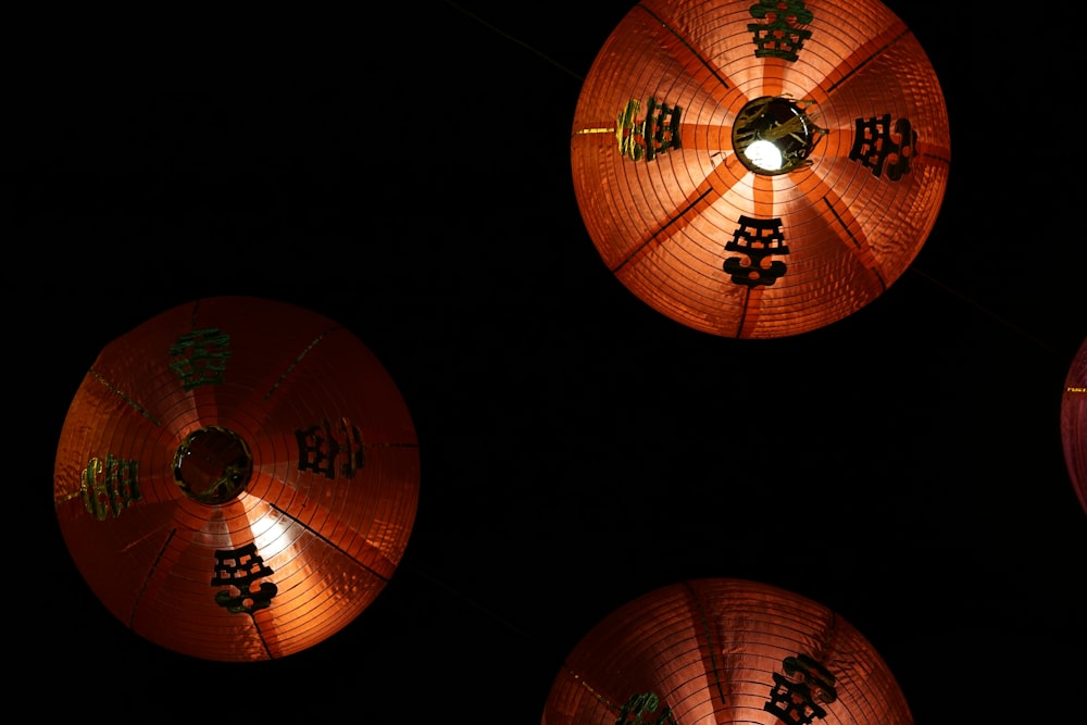 three chinese lanterns lit up in the dark