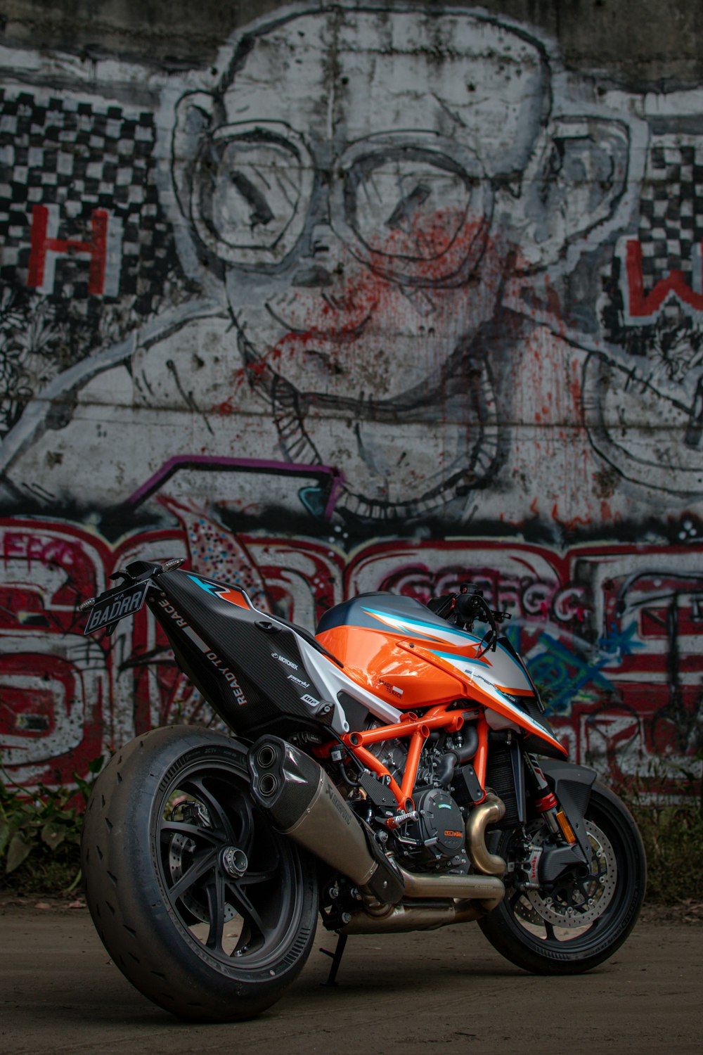 a motorcycle parked in front of a graffiti covered wall