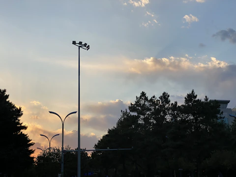 Technicians installing smart sensors on a city lamppost at dusk.