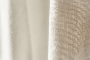 Close-up of finely woven cashmere fabric in soft beige, highlighting its luxurious texture.