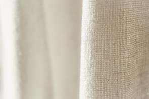 Close-up of textured fabric details in neutral tones, highlighting craftsmanship.