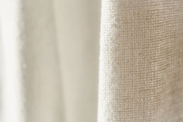 Close-up of a cream oversized sweatshirt with subtle stitching details, highlighting the premium fabric texture
