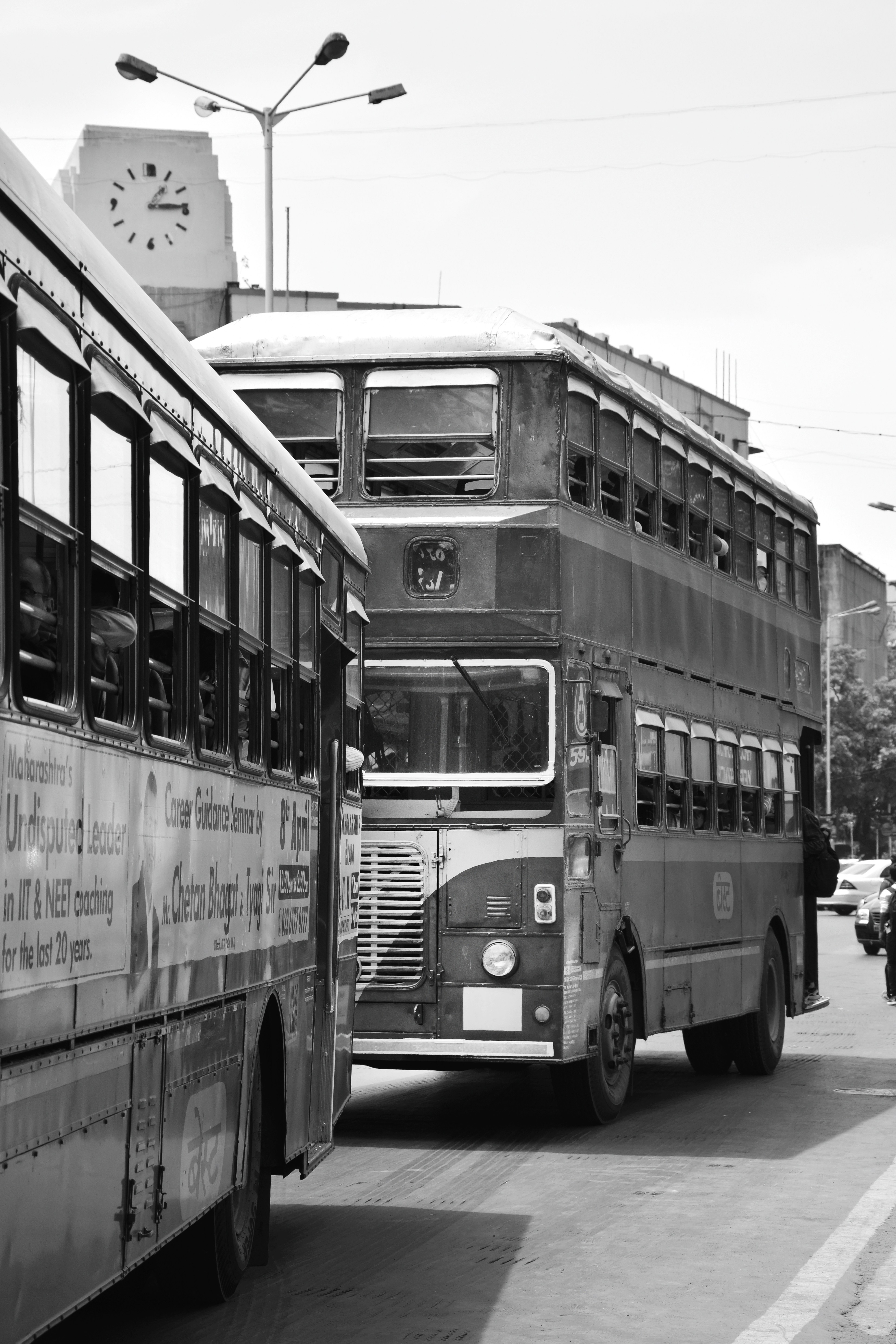 a black and white photo of a bus and a motorcycle