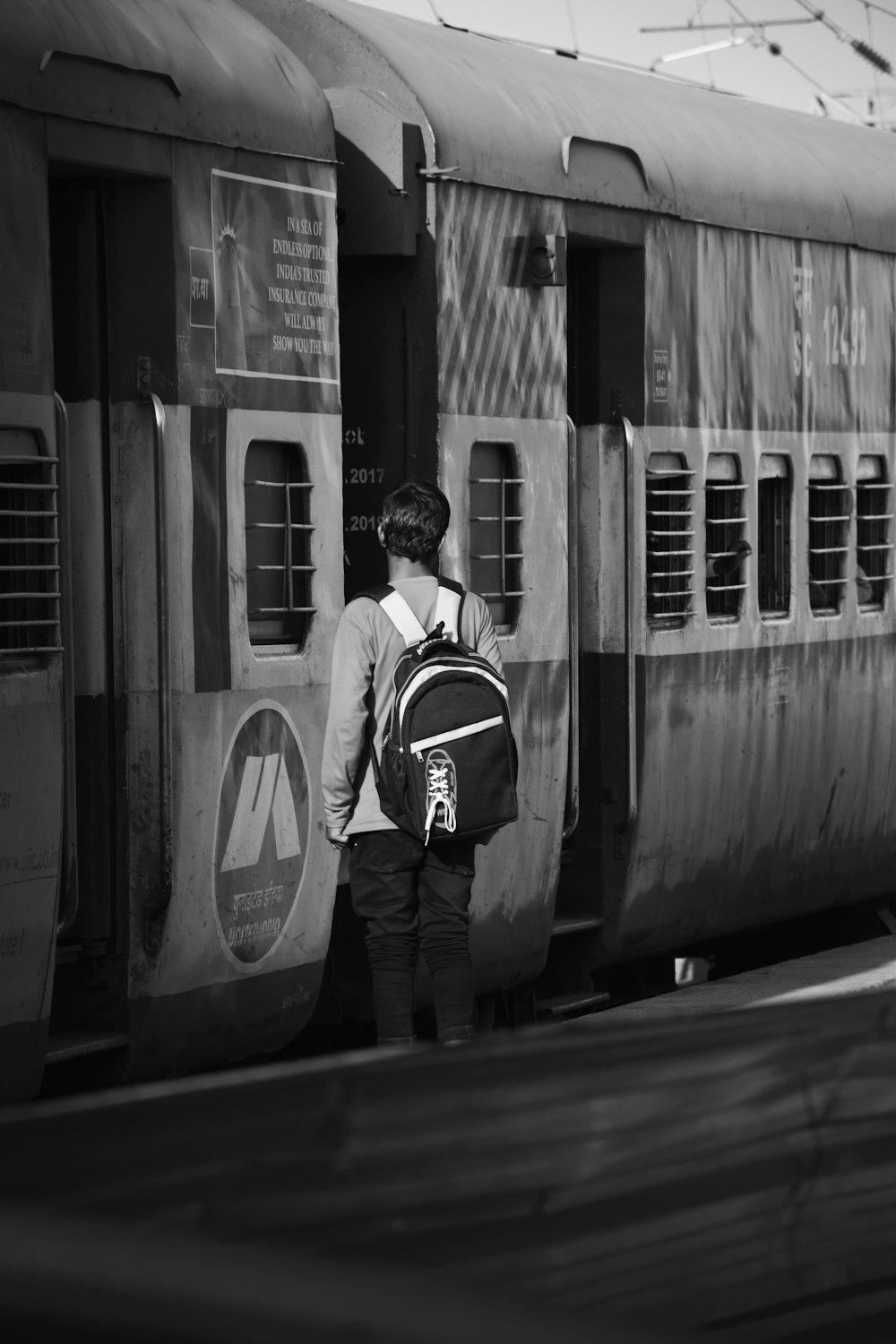 a person with a backpack standing next to a train