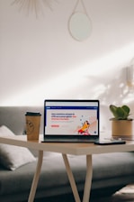 a laptop computer sitting on top of a wooden table