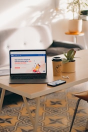 a laptop computer sitting on top of a wooden table